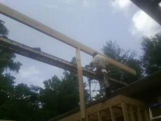 Carpenter setting a ridge beam over a new addition frame — Ice Dam Removal by Roofing Brothers in Halstad