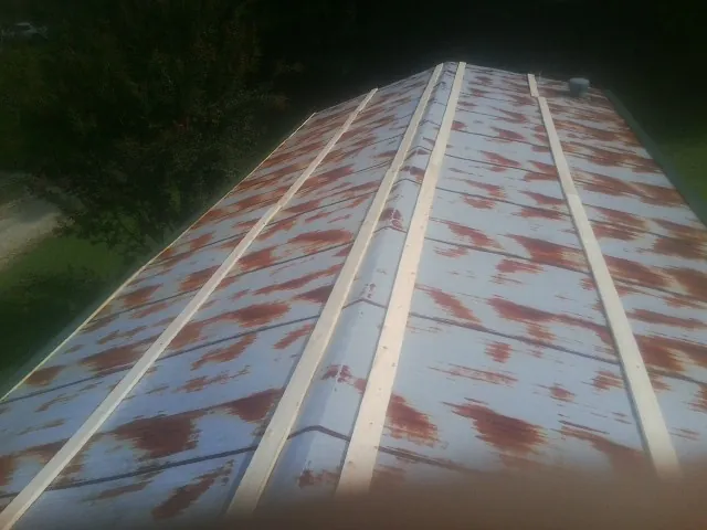 Rusted metal roof panels with new wood purlins before replacement — Storm Damage Roof Repair in Halstad by Roofing Brothers